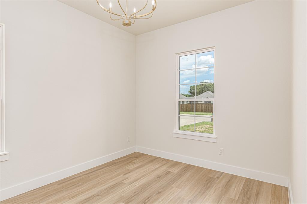 360 Dalton Road Canton, TX 75103 - Photo 24 of 33 Bright interior space featuring a window with grid panes, wood-finish flooring, white baseboards, and a gold-toned chandelier