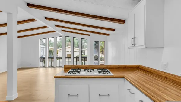 a kitchen with a stove and a white wooden cabinets