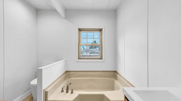 a bathroom with bathtub and window