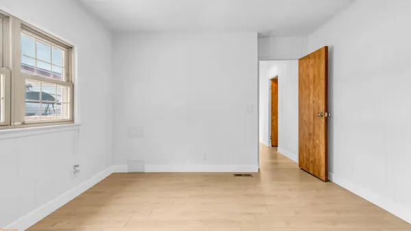 an empty room with windows and closet