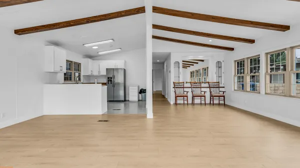 a view of a livingroom with kitchen and a window