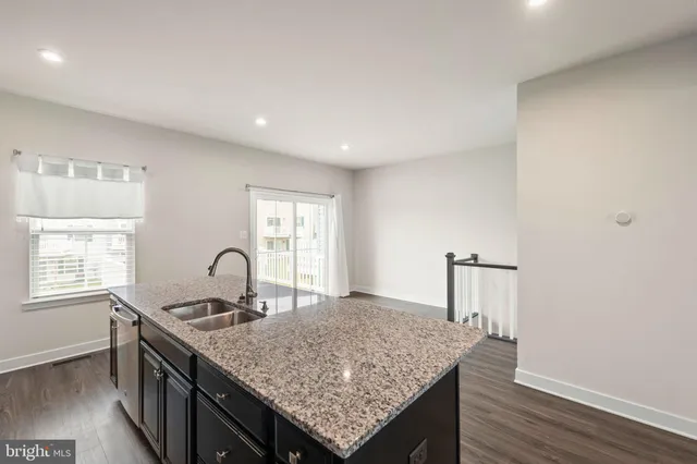 a kitchen with granite countertop a stove and a wooden floor