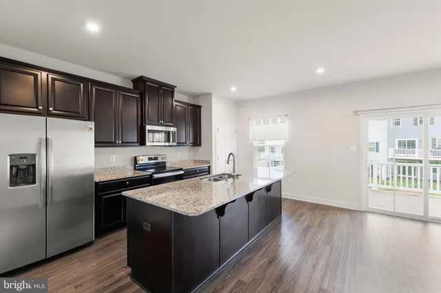 a kitchen with stainless steel appliances granite countertop a stove a sink and a refrigerator