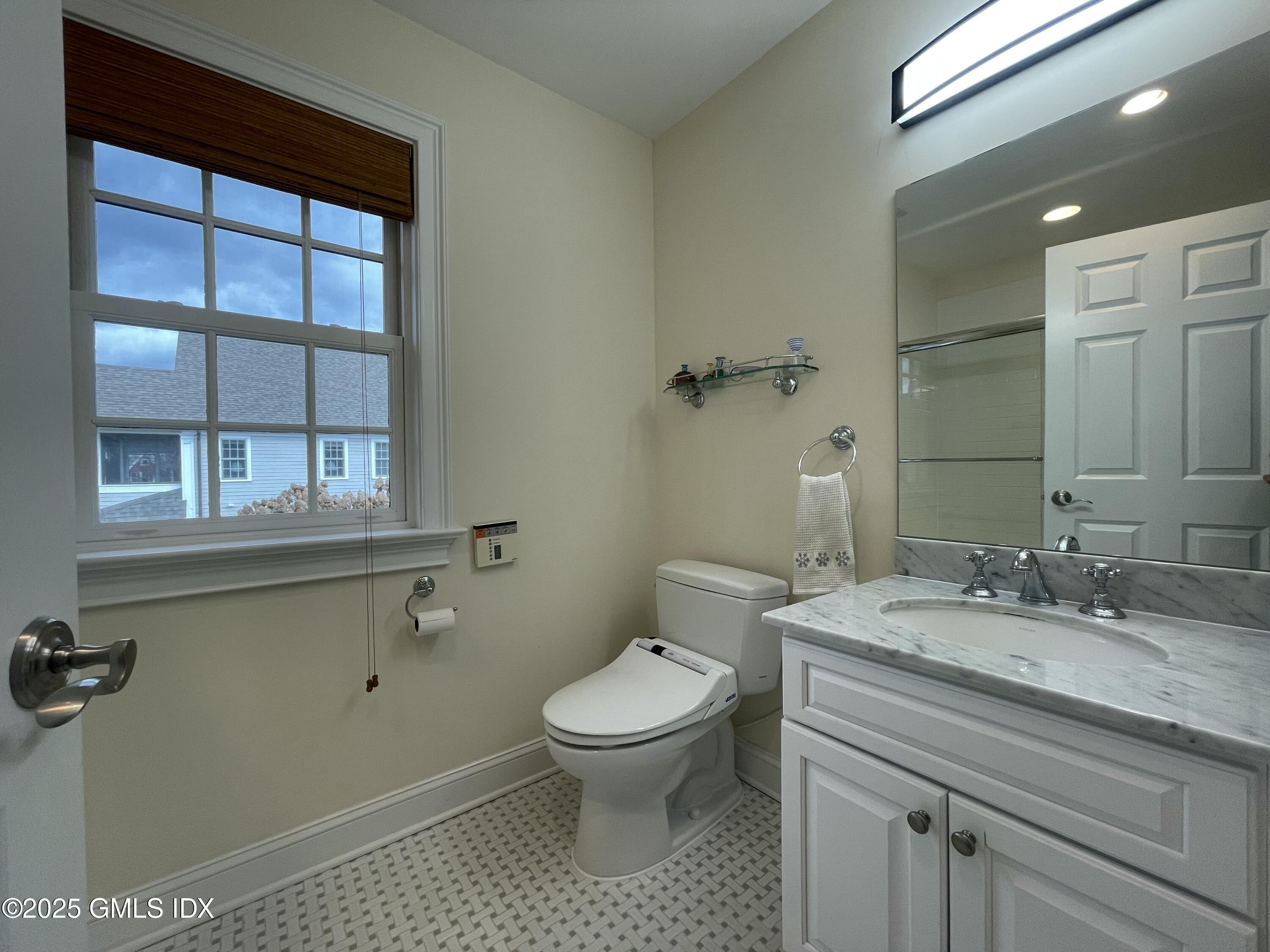 1 Northfield Street, Unit B Greenwich, CT 06830 - Photo 24 of 30 a bathroom with a granite countertop sink a toilet and a window