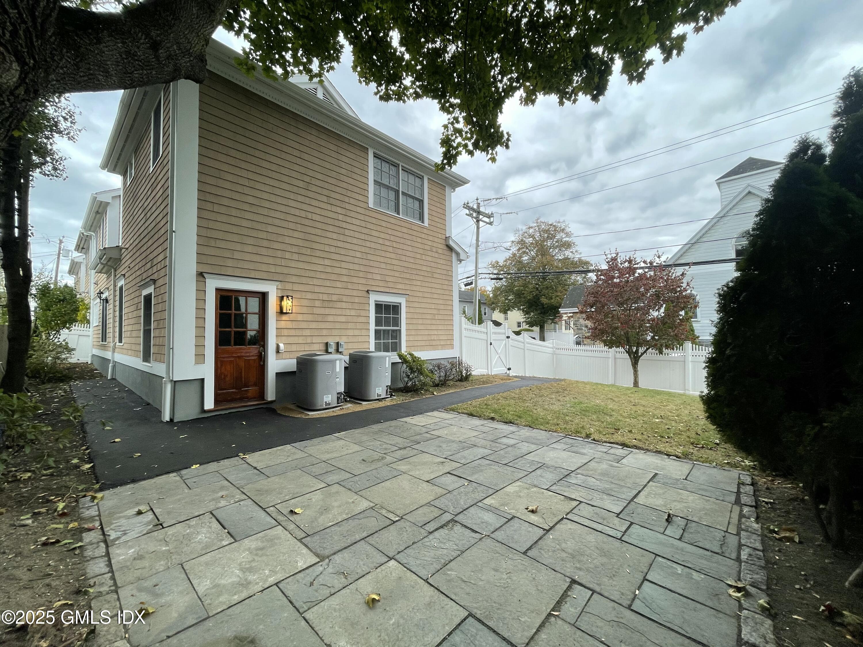 1 Northfield Street, Unit B Greenwich, CT 06830 - Photo 28 of 30 a view of a white house with a yard and large trees