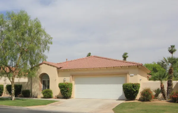 a front view of a house with a yard and a garage