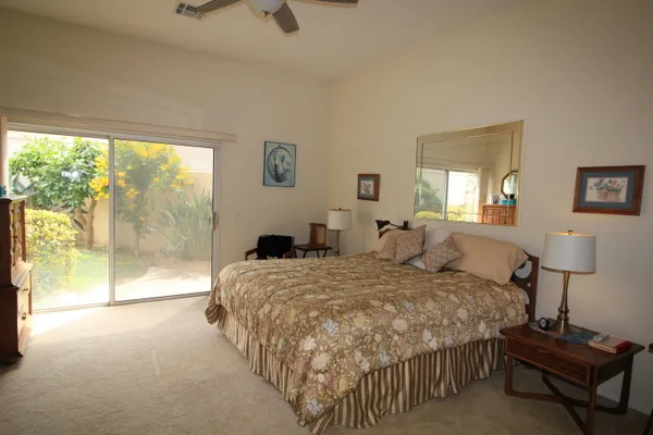 a large bedroom with a bed and large window