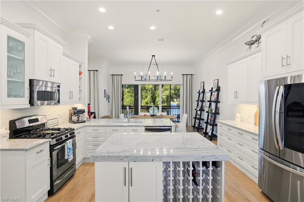9263 Museo Circle, Unit 202 Naples, FL 34114 - Photo 13 of 50 a kitchen with stainless steel appliances kitchen island granite countertop a stove and a refrigerator