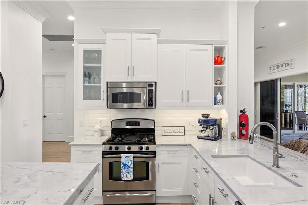 9263 Museo Circle, Unit 202 Naples, FL 34114 - Photo 15 of 50 a kitchen with stainless steel appliances granite countertop a sink stove and refrigerator