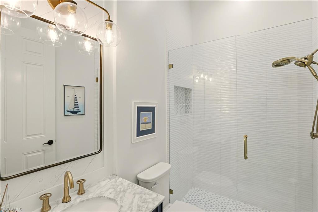 9263 Museo Circle, Unit 202 Naples, FL 34114 - Photo 33 of 50 a bathroom with a granite countertop sink toilet and shower