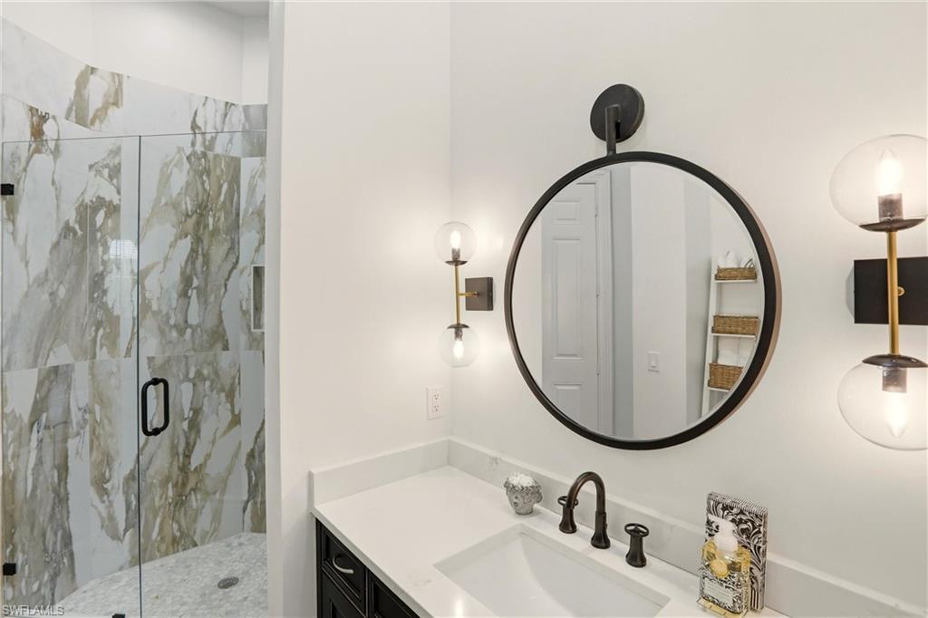 9263 Museo Circle, Unit 202 Naples, FL 34114 - Photo 35 of 50 a bathroom with a sink and a mirror