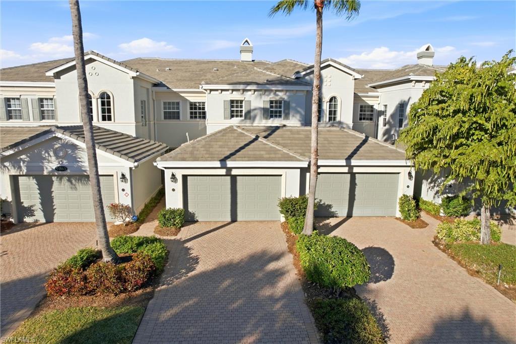 9263 Museo Circle, Unit 202 Naples, FL 34114 - Photo 42 of 50 a view of a white house next to a yard with potted plants