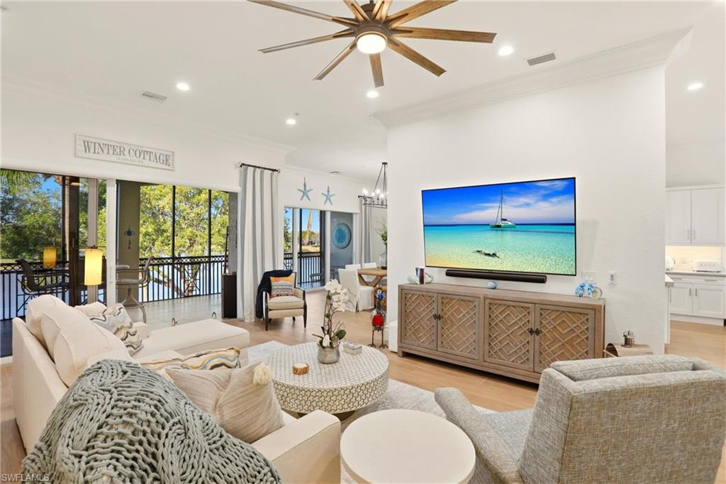 9263 Museo Circle, Unit 202 Naples, FL 34114 - Photo 5 of 50 a living room with furniture a large window and a flat screen tv