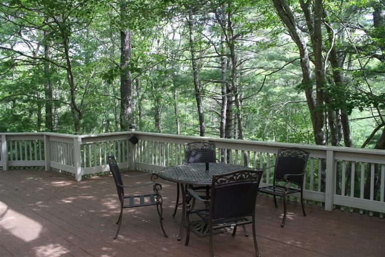 103 Paddock Circle Mashpee, MA 02649 - Photo 27 of 27 a view of a wooden deck with chairs and a trees