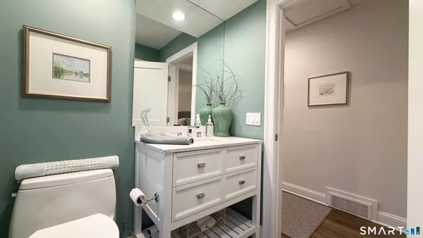 a bathroom with a toilet a sink and mirror