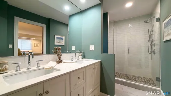a bathroom with a double vanity sink mirror and shower