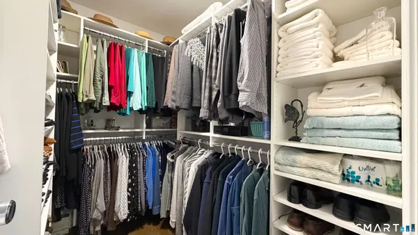 a view of walk in closet with clothes and shoes