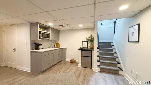 a large white kitchen with sink and stainless steel appliances