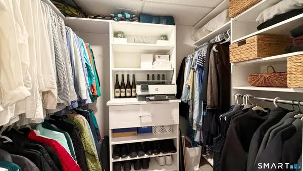 a view of walk in closet with clothes and shoes