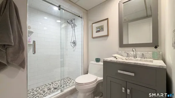 a bathroom with a granite countertop sink toilet and shower