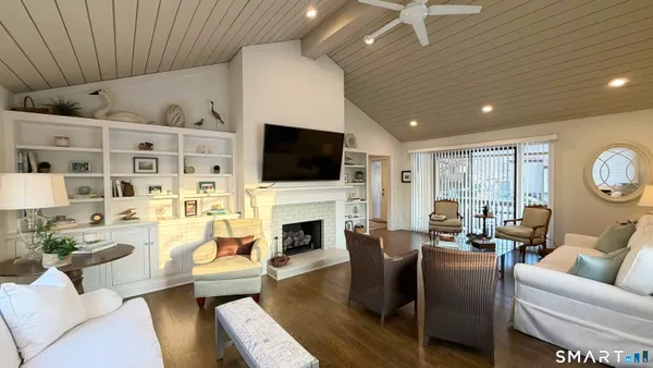 a living room with furniture a fireplace and a flat screen tv