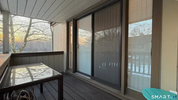 a view of a balcony with wooden floor and door