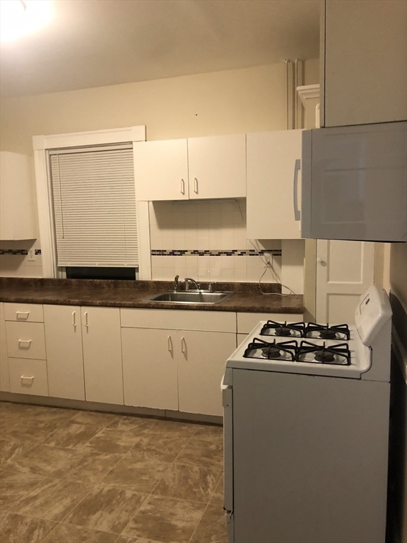 180 Lewis Street, Unit 2 Lynn, MA 01902 - Photo 6 of 14 a kitchen with granite countertop a sink stove and cabinets