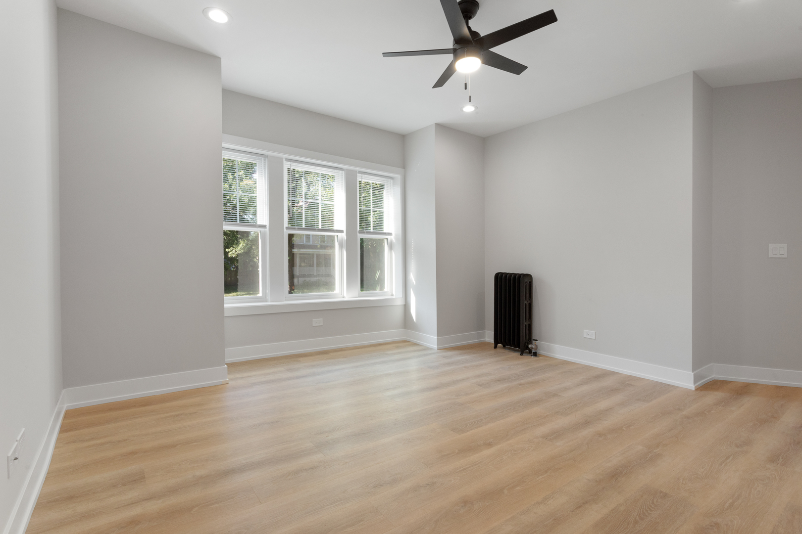1904 West Morse Avenue, Unit 1 Chicago, IL 60626 - Photo 2 of 15 a view of an empty room with a window and wooden floor