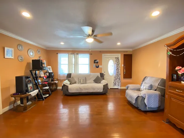 a living room with furniture and a flat screen tv with kitchen view