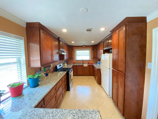 a kitchen with stainless steel appliances granite countertop sink refrigerator and window