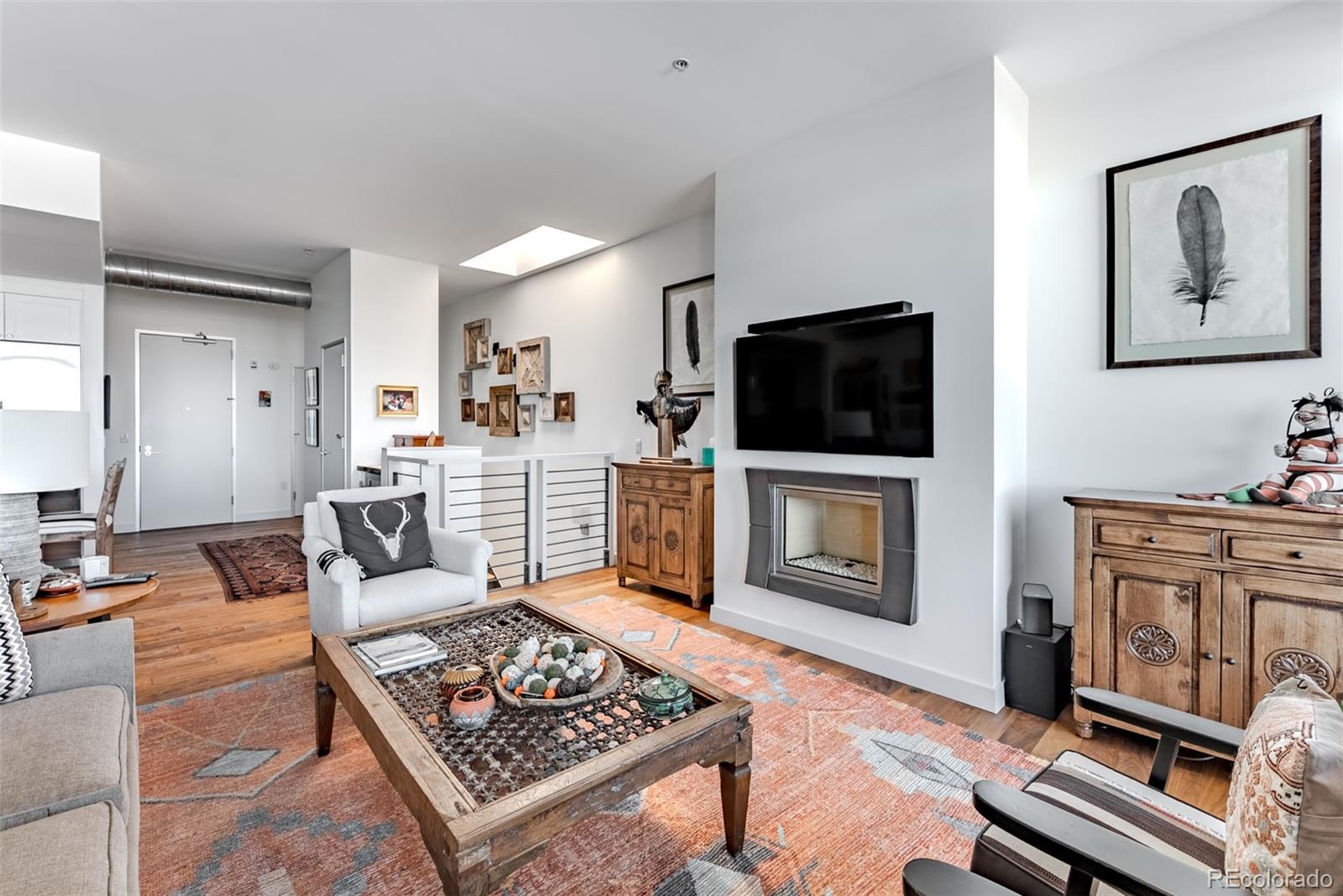 2229 Blake Street, Unit 709 Denver, CO 80205 - Photo 14 of 40 a living room with furniture a flat screen tv and a stove