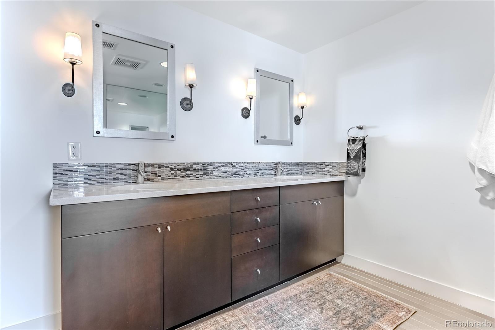 2229 Blake Street, Unit 709 Denver, CO 80205 - Photo 26 of 40 a bathroom with a granite countertop sink and a mirror