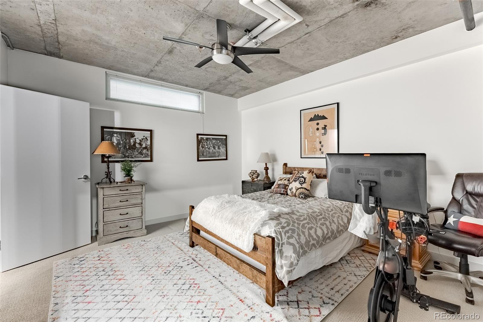2229 Blake Street, Unit 709 Denver, CO 80205 - Photo 28 of 40 a bedroom with a bed and ceiling fan