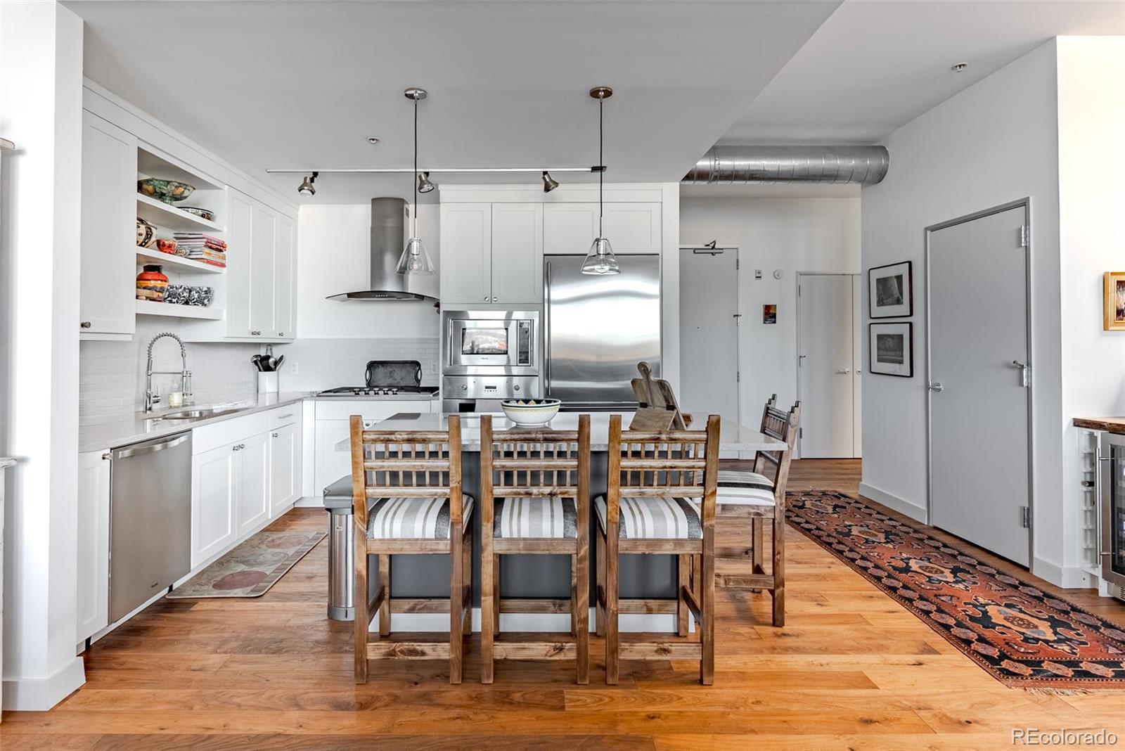 2229 Blake Street, Unit 709 Denver, CO 80205 - Photo 4 of 40 a kitchen with granite countertop white cabinets and stainless steel appliances