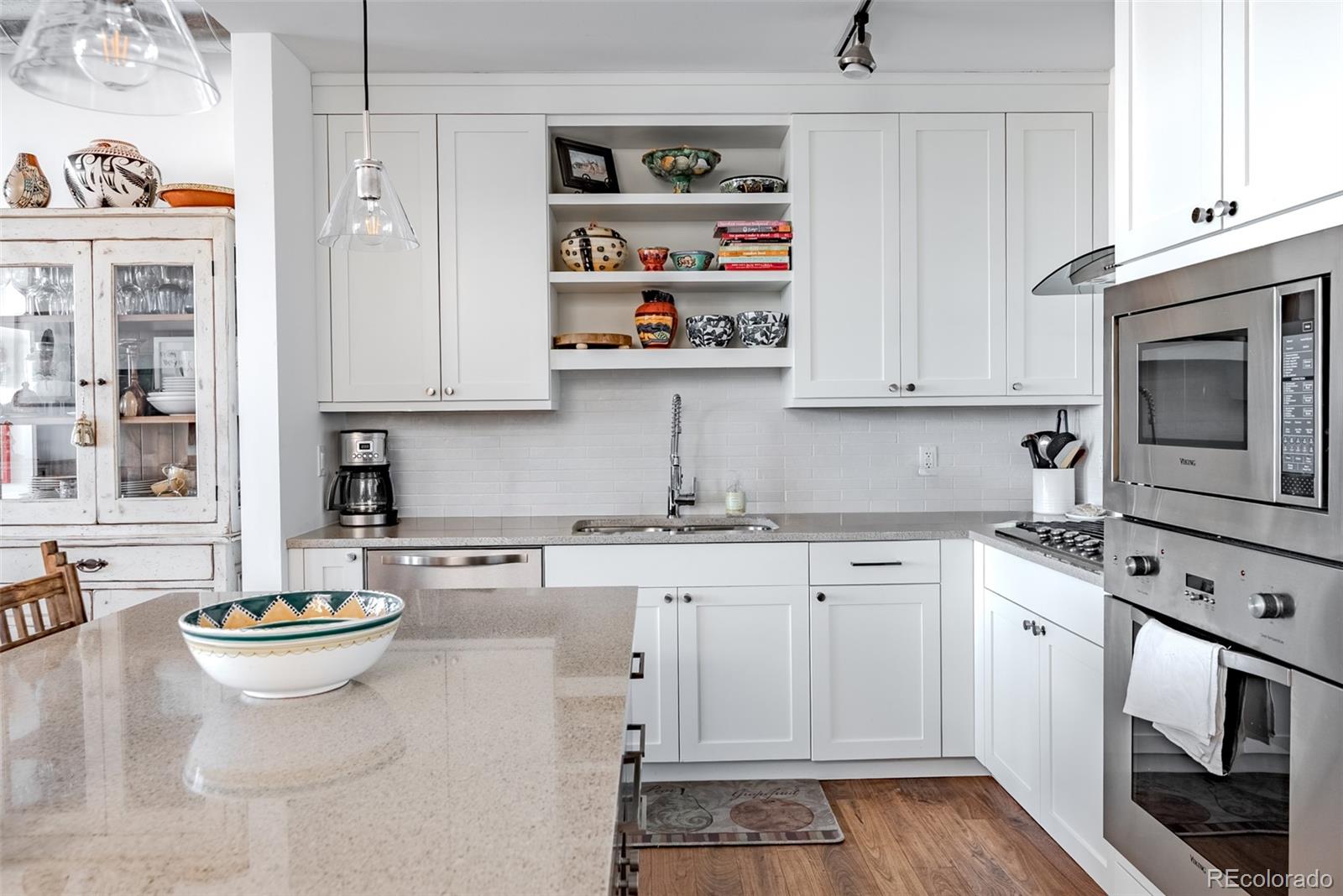 2229 Blake Street, Unit 709 Denver, CO 80205 - Photo 7 of 40 a kitchen with stainless steel appliances granite countertop a stove a sink and white cabinets
