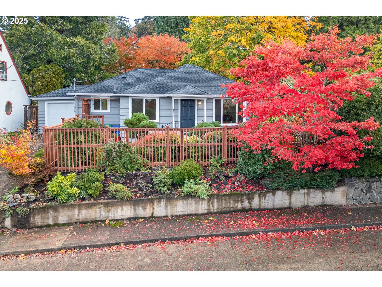 a front view of a house with a yard with potted plants