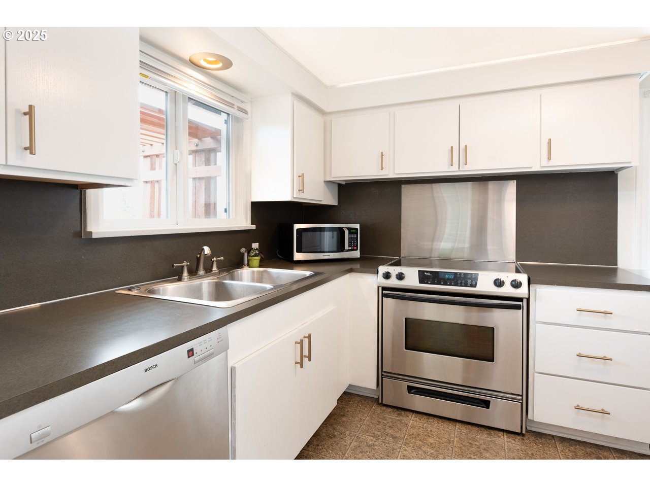 2575 Chula Vista Boulevard Eugene, OR 97403 - Photo 15 of 40 a kitchen with granite countertop a sink cabinets stainless steel appliances and a window