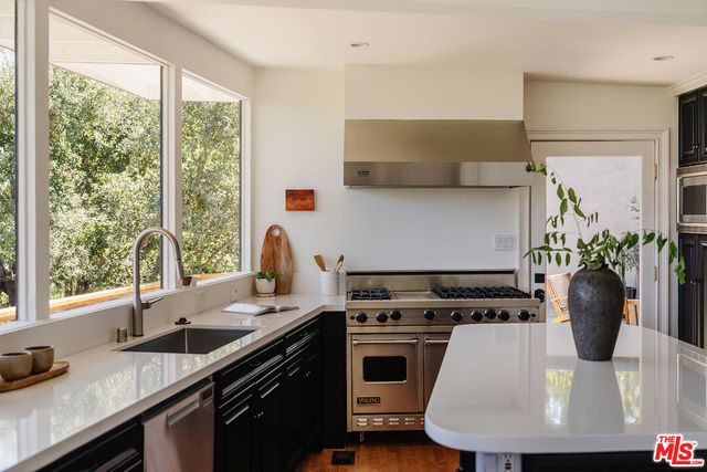 a kitchen with a sink and large windows