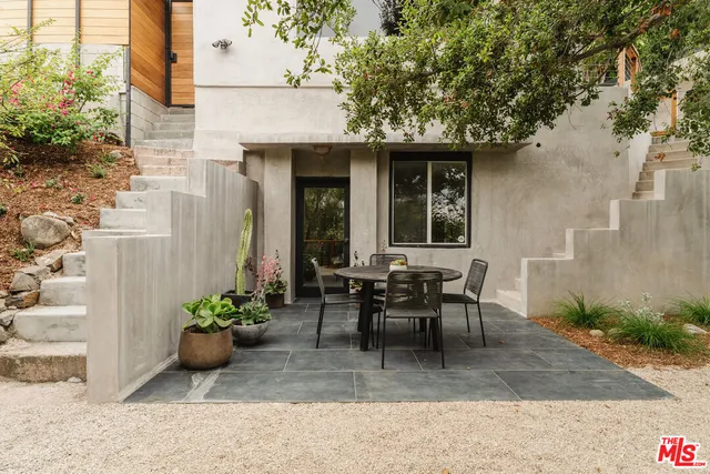 a view of backyard with table and chairs and a large tree