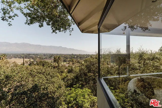 a view of a living room with a floor to ceiling window and an outdoor view