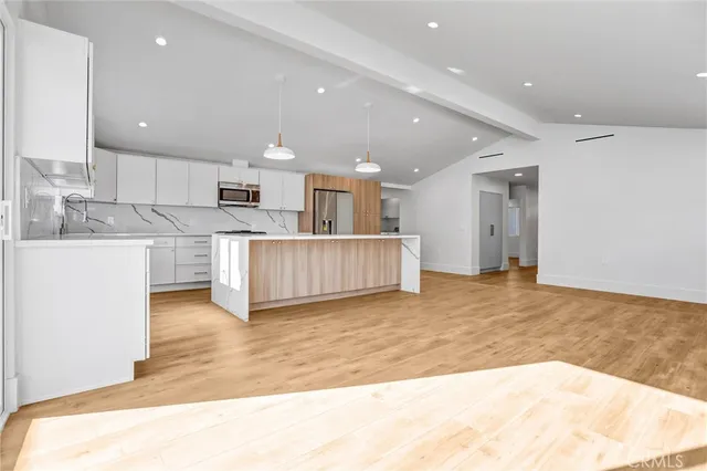 a view of a kitchen with kitchen island wooden floor and center island