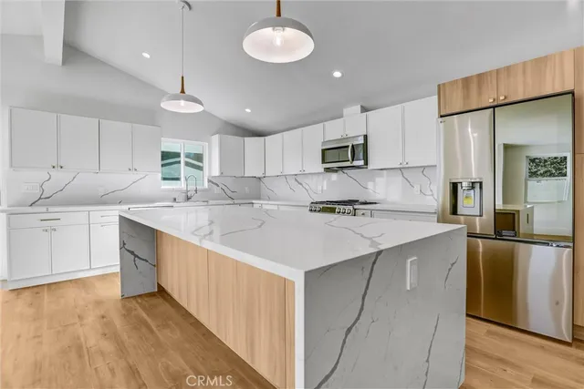 a kitchen with kitchen island a sink stainless steel appliances and cabinets