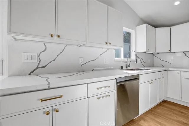 a view of a kitchen with a sink and wooden floor