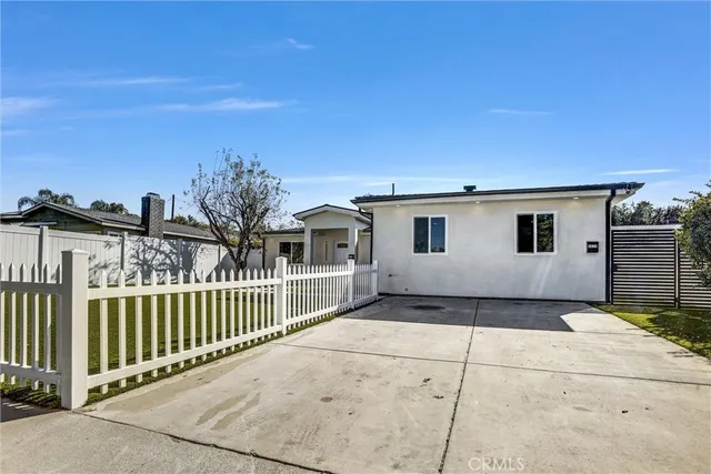 a view of a house with a small yard and wooden fence