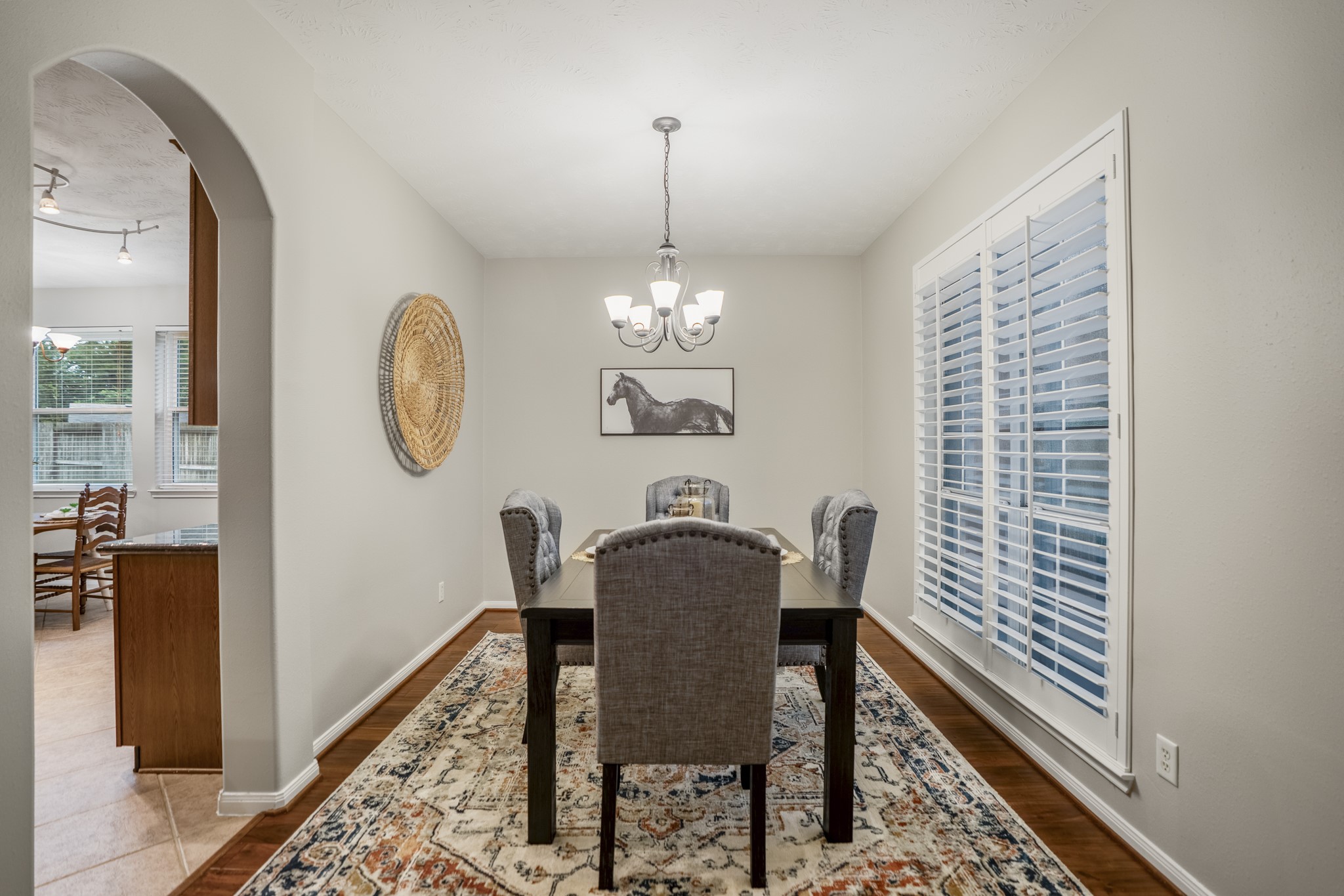 6311 Sparrows Glen Lane Spring, TX 77379 - Photo 6 of 50 Framed by plantation shutters and a softly defined arched opening, the formal dining room brings a polished first impression near the front of the home, with the kitchen and breakfast area just beyond for an easy connection between everyday meals and hosting.