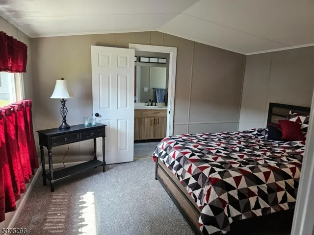 a bedroom with a bed and a lamp on dresser
