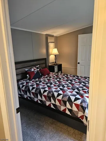 a bedroom with a bed and a lamp on dresser