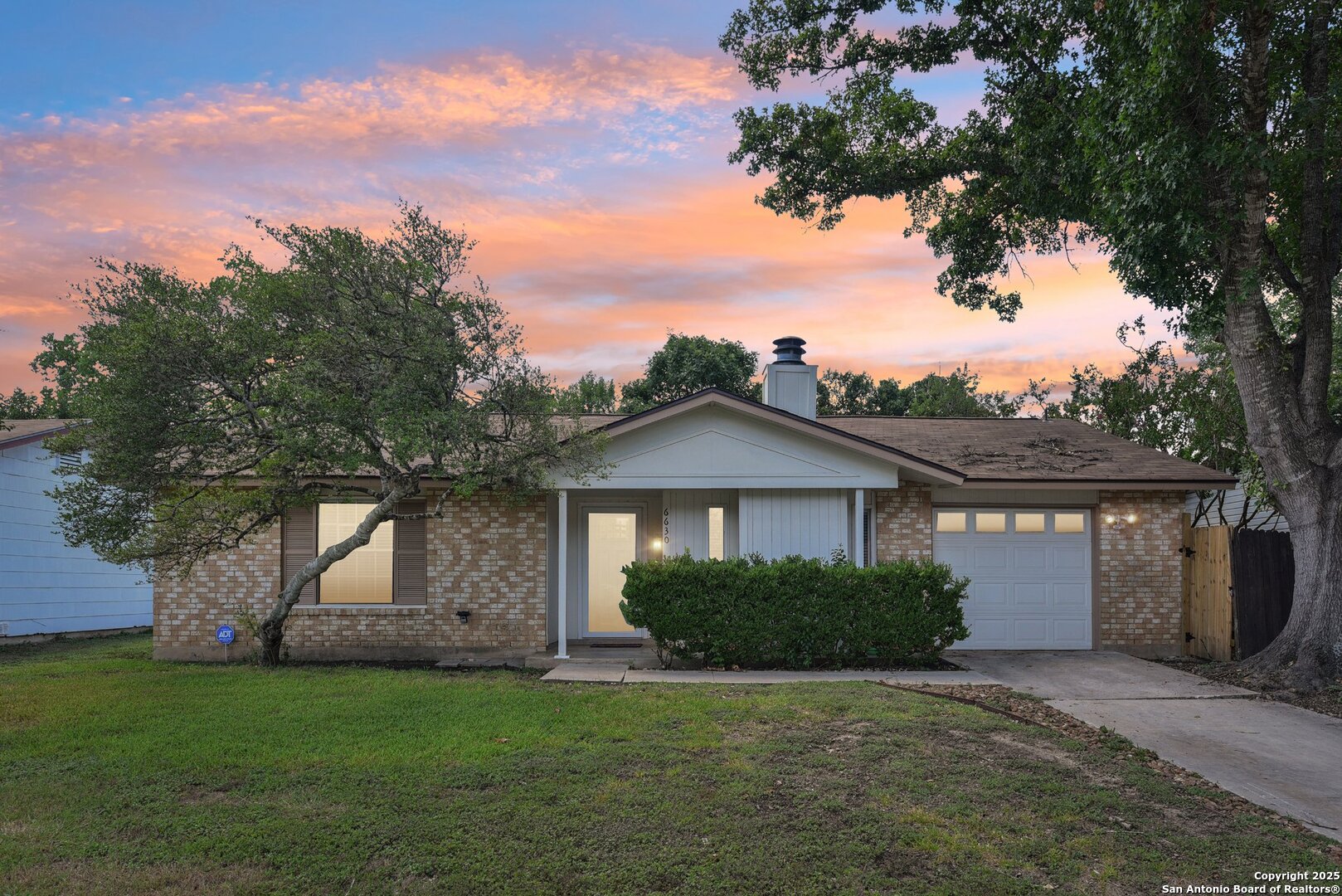 6630 Spring Hollow Street San Antonio, TX 78249 - Photo 1 of 40 a front view of a house with a garden