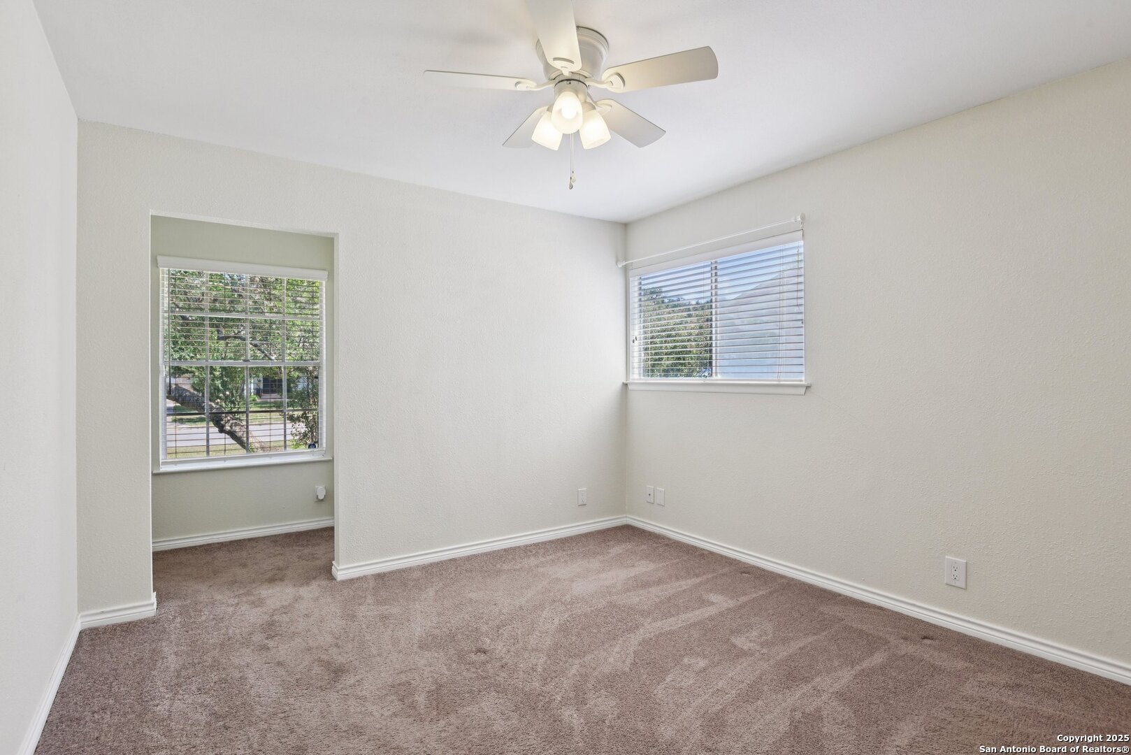 6630 Spring Hollow Street San Antonio, TX 78249 - Photo 28 of 40 an empty room with chandelier fan and windows