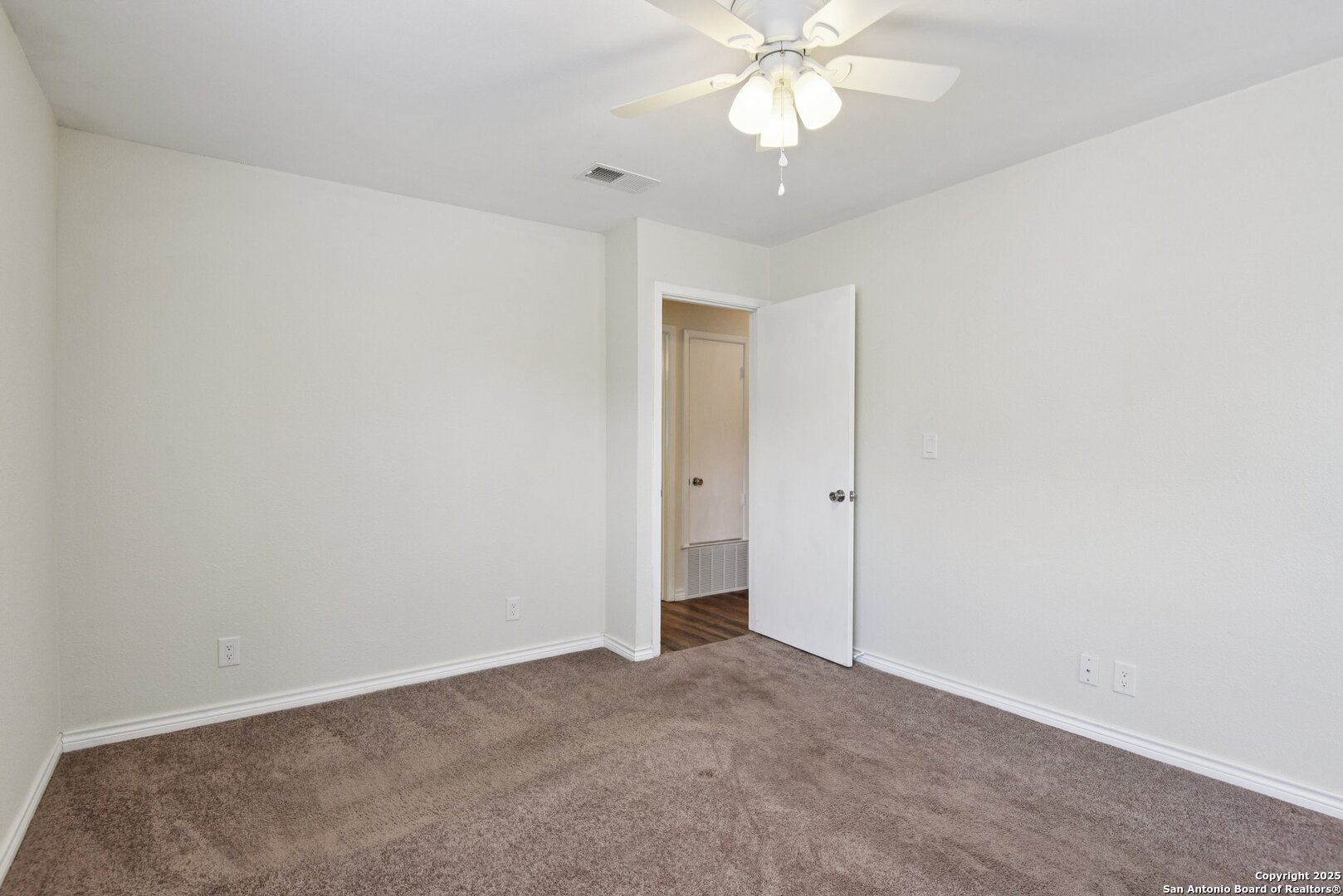 6630 Spring Hollow Street San Antonio, TX 78249 - Photo 30 of 40 an empty room with a chandelier fan and a bathroom